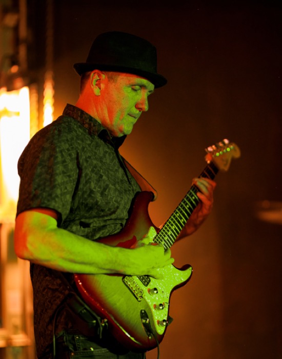 Avram Adam playing a Stratocaster on stage